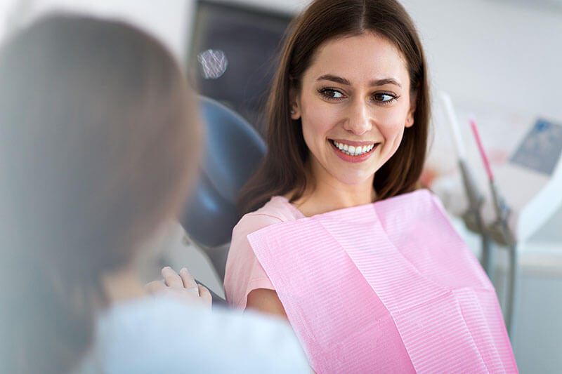 young female patient smiling during a dental exam