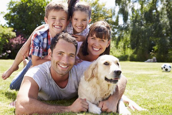 happy family and their dog at the park